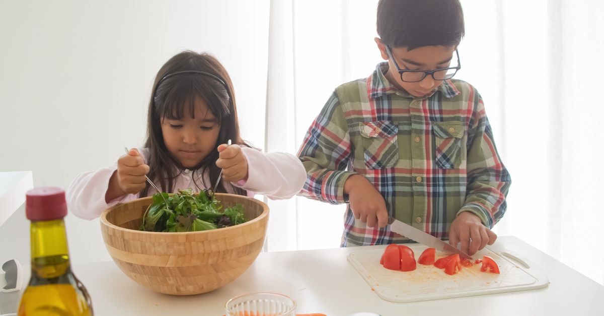 Crianças preparando alimentos saudáveis em uma atividade de educação alimentar