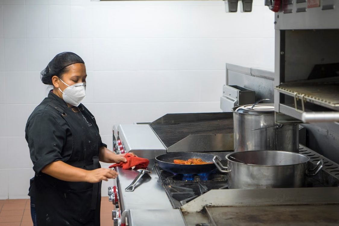 Profissional em cozinha comercial seguindo processos padronizados